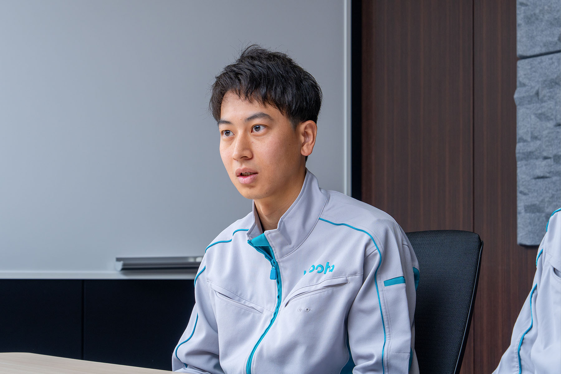 Ginji Matsuoka answers interview questions in a conference room.