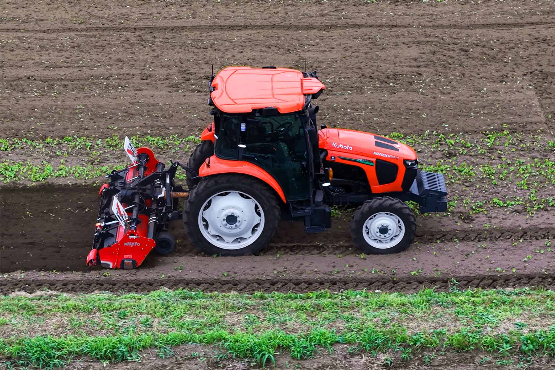 A New Agri Robo Tractor with an implement connected performs unmanned work under remote monitoring.